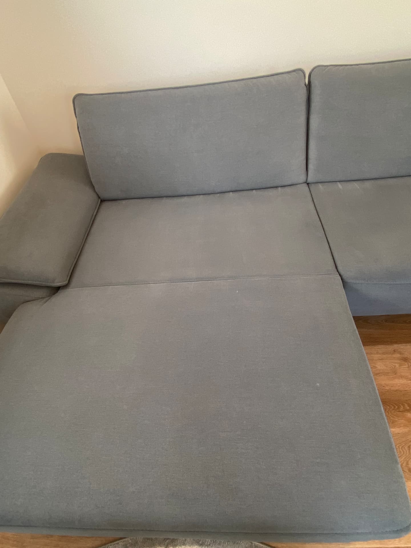 Dasselbe graue Ecksofa sauber nach der Polsterreinigung